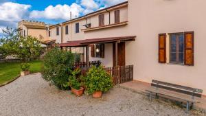 a house with a bench and plants in front of it at Podere Santo Signoretto in San Vincenzo