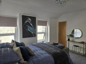 Un dormitorio con una cama con un edredón azul. en Seasalt Apartment, en Barmouth