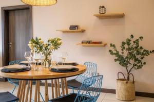 a dining room table with chairs and wine glasses at The Skies by YourHost Nairobi in Nairobi