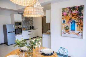 a kitchen with a table and a painting on the wall at The Skies by YourHost Nairobi in Nairobi