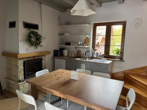 a kitchen with a wooden table and a fireplace at Villa Wejsunka in Wejsuny