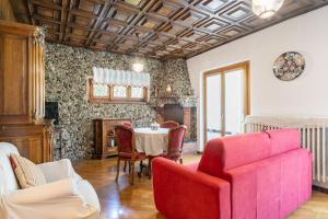 un soggiorno con un divano rosso e un tavolo di IRIS - Relaxing Alpine Getaway at Ballabio a Ballabio