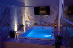 eine große Badewanne in einem Badezimmer mit einer Steinwand in der Unterkunft Palazzo Bruca Catania in Catania