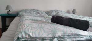 an unmade bed in a bedroom with a table at Kossuth Apartman in Hidasnémeti