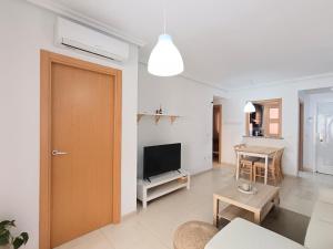 a living room with a door and a tv and a table at Ayf playa dorada 1ª linea de mar in El Borseral