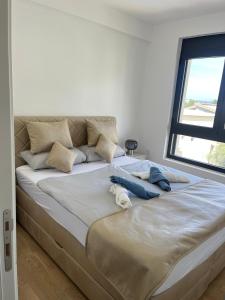 ein großes Bett in einem Zimmer mit Fenster in der Unterkunft Apartment ENJOY in Bar + 20 Fotos