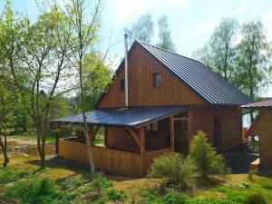 a large wooden house with a metal roof at Chaty u rybníka in Bohdalov