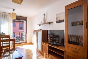 a living room with a flat screen tv and a entertainment center at Apartamento Brisa de Cantábrico-piscina y parking in Prellezo