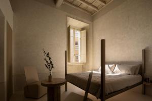 a bedroom with a bed and a table and a window at Nomos Hotel in Rome