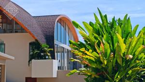 a house with a large green plant next to it at Santi Pura Villas in Koh Samui 
