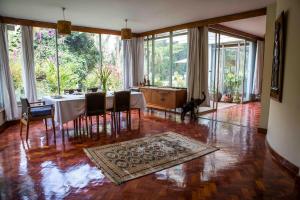 内罗毕Beautiful historic stand alone in Muthaiga, Nairobi的餐厅里有一张桌子和一只狗