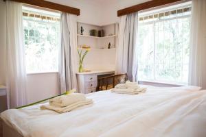 内罗毕Beautiful historic stand alone in Muthaiga, Nairobi的卧室里有一张白色的床，床上放着毛巾