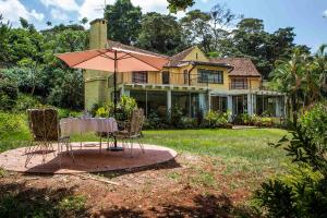 内罗毕Beautiful historic stand alone in Muthaiga, Nairobi的房子前面的一张带伞的桌子
