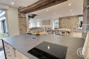 a kitchen and dining room with a stone wall at La maison de oueval in Frehel