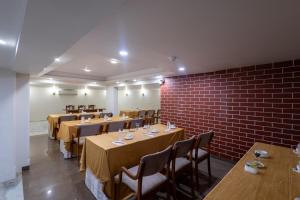 a restaurant with tables and chairs and a brick wall at Hotel Pravasa Stay in Vadodara