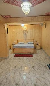 a bedroom with a bed and a chandelier at Shree Guru Home Stay in Jāmb
