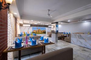 a dining room with blue chairs and tables at Hotel Pravasa Stay in Vadodara