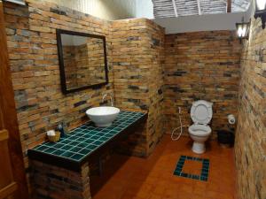 a brick bathroom with a sink and a toilet at Relax Bay Resort in Ko Lanta
