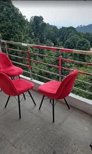 two red chairs sitting on top of a balcony at Shree Guru Home Stay in Jāmb
