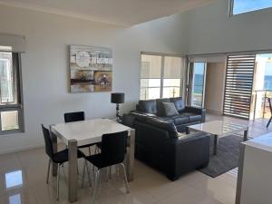 a living room with a couch and a table at Bunbury Seaview Apartments in Bunbury