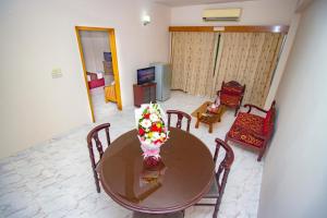 a room with a table with a vase of flowers on it at Laurel Lakefront Hotel in Dhaka