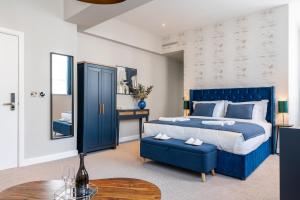 een slaapkamer met een blauw bed en een blauwe stoel bij Above Hotels in Burnley