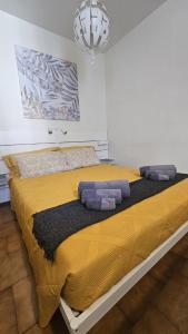 a large yellow bed in a bedroom with a chandelier at Ca' Tecla in Asti