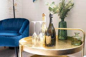 a table with wine bottles and a blue chair at Above Hotels in Burnley