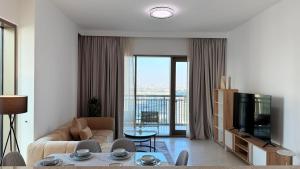 a living room with a couch and a television at Premium 2 Bedroom Creek Horizon in Dubai