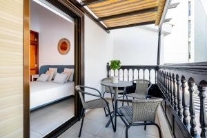 a balcony with a bed and a table and chairs at Playa de San Juan - Santa Martha duplex in Playa de San Juan