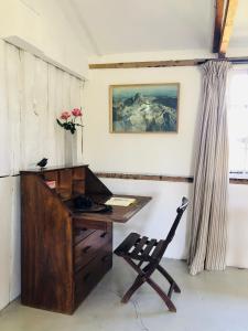 The Barn by YourHost Nanyuki Kenya في نانيوكي: مكتب به مكتب خشبي وكرسي