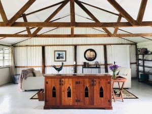 a living room with a wooden table and a couch at The Barn by YourHost Nanyuki Kenya in Nanyuki