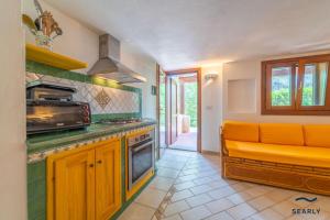 a kitchen with an orange couch in a room at Stintino #9a Casa Giardino - By Searly in Stintino