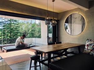 a man sitting on the floor in a room with a table at 80 Colonie Fraser's Hill 4pax in Bukit Fraser