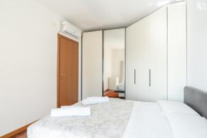 two beds in a bedroom with white walls and mirrors at Large well-equipped appartement near Como lake in Lecco