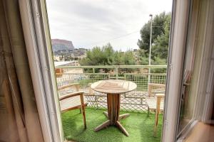 a balcony with a table and chairs and a window at Cassis Centre, proximité port, plages et calanques in Cassis