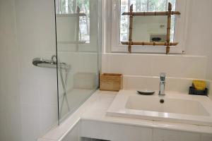 a white bathroom with a sink and a shower at Cassis Centre, proximité port, plages et calanques in Cassis