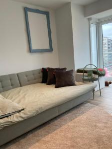 a bed with pillows on it in a living room at Appartement San Marino 4B in Middelkerke