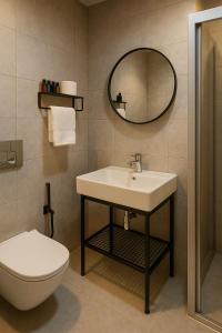 Un baño con lavabo, inodoro y espejo. en Blue Point Hotel, en Estambul