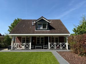 une petite maison avec une fenêtre et une pelouse dans l'établissement The Cosy Cottage for Comfort with Sauna and Hottub, à Zeewolde 30 autres photos