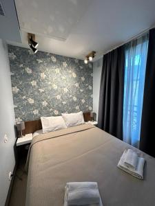 1 dormitorio con 1 cama grande y papel pintado con motivos florales en MULTIRESIDENCE L'ELYSEE Paris, en París