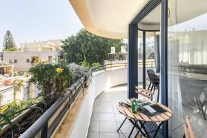 特拉维夫Chic 3BR Apt w Balcony & Parking by Tel Aviv Port by Sea N' Rent的阳台配有桌椅。