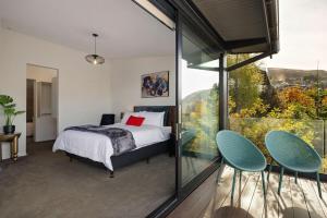 a bedroom with a bed and a large window at Lakevista Retreat - Hot Tub - Spa Pool in Queenstown