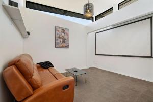 a living room with a couch and a projection screen at Lakevista Retreat - Hot Tub - Spa Pool in Queenstown +23 photos