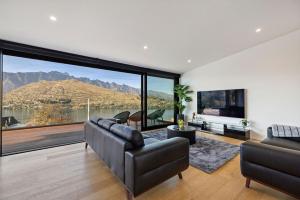 a living room with a couch and a large window at Lakevista Retreat - Hot Tub - Spa Pool in Queenstown