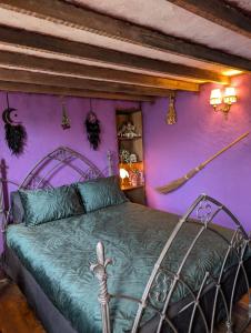 a bedroom with a bed with a purple wall at Witchcraft and Wizardry - York in York