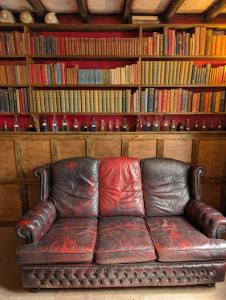 a leather couch sitting in front of a book shelf at Witchcraft and Wizardry - York in York