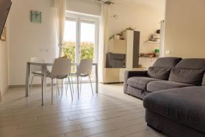 een woonkamer met een bank, een tafel en stoelen bij Estate By Case al Lago in Desenzano del Garda