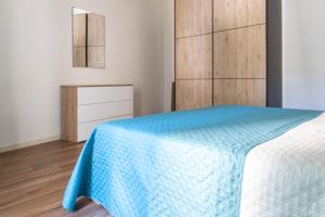a bedroom with a bed with a blue blanket at ORA APARTMENT Centro Desenzano del Garda By Case al Lago in Desenzano del Garda