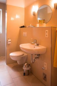 a bathroom with a sink and a toilet and a mirror at Familie Schwantes in Buxtehude